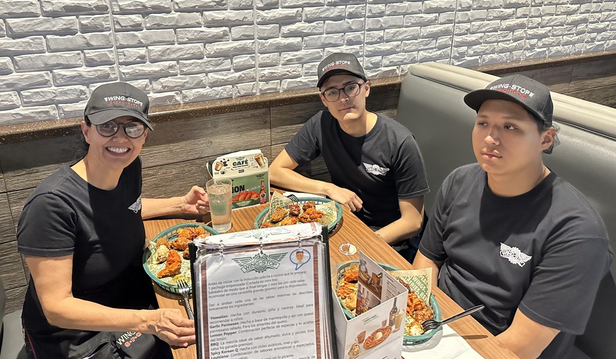 Bárbara Castro y parte del equipo de Wingstop, con uniforme, durante el trabajo de campo